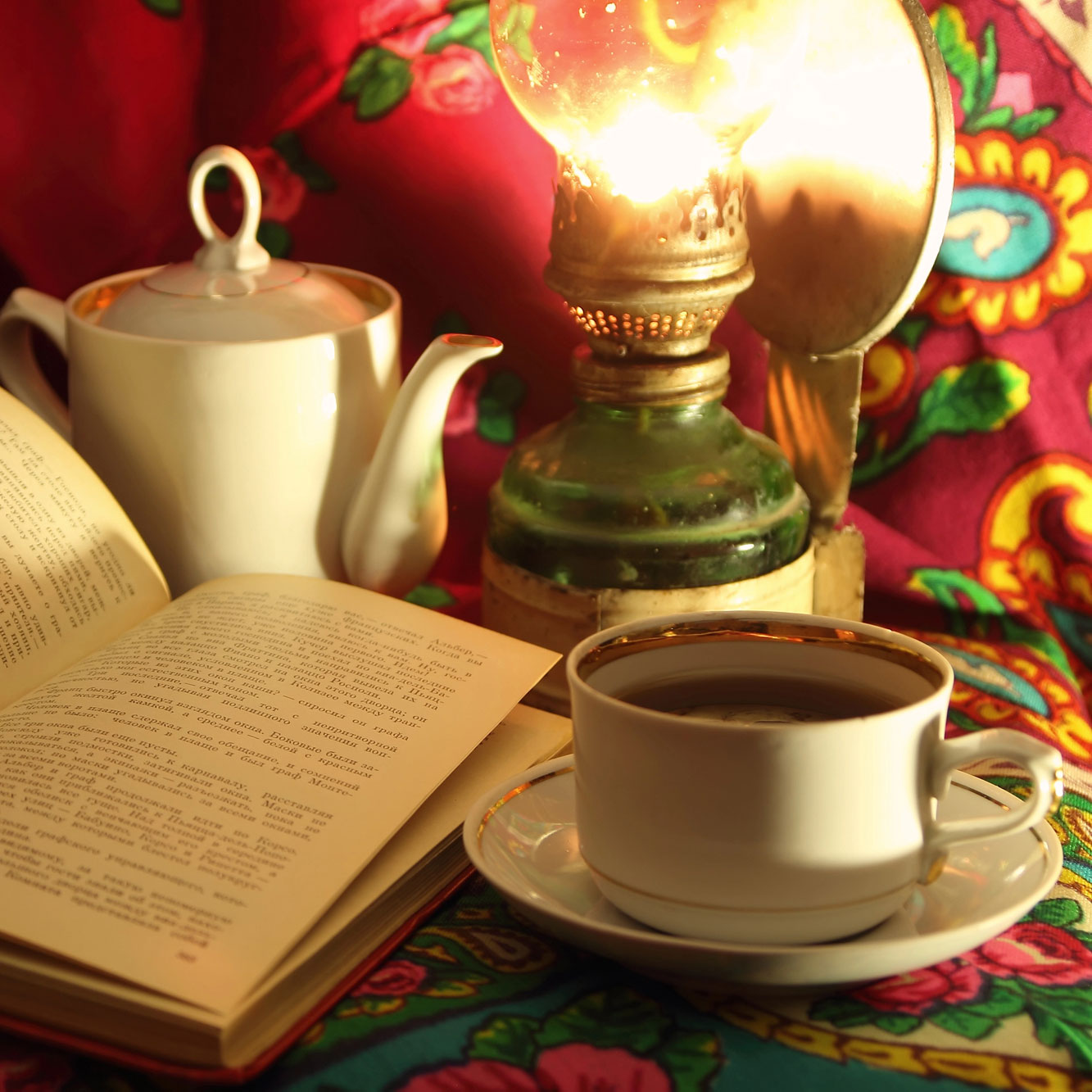 beautifully displayed cup, samovar, textile, book in warm colors